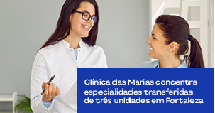 Médica conversa com paciente e faz anotações no consultório.